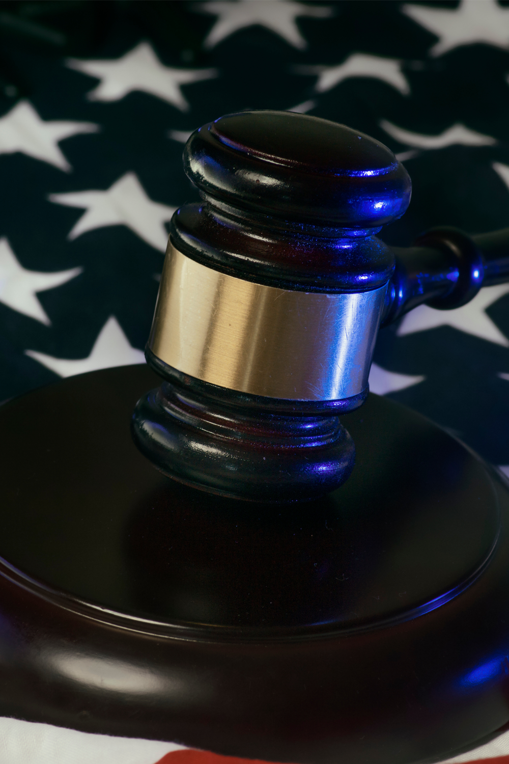 Judge’s gavel in front of the United States flag, symbolizing justice under federal law