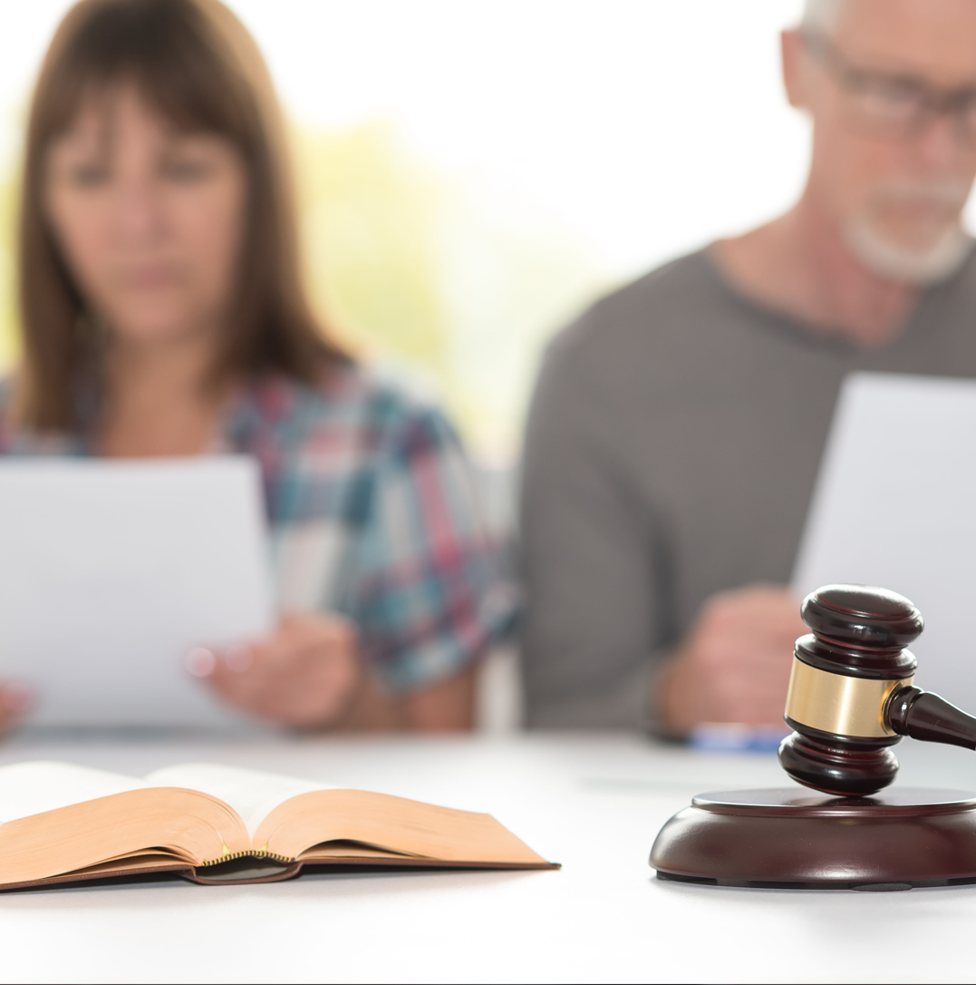 Lawyer guiding a couple through collaborative divorce discussions with documents on the table