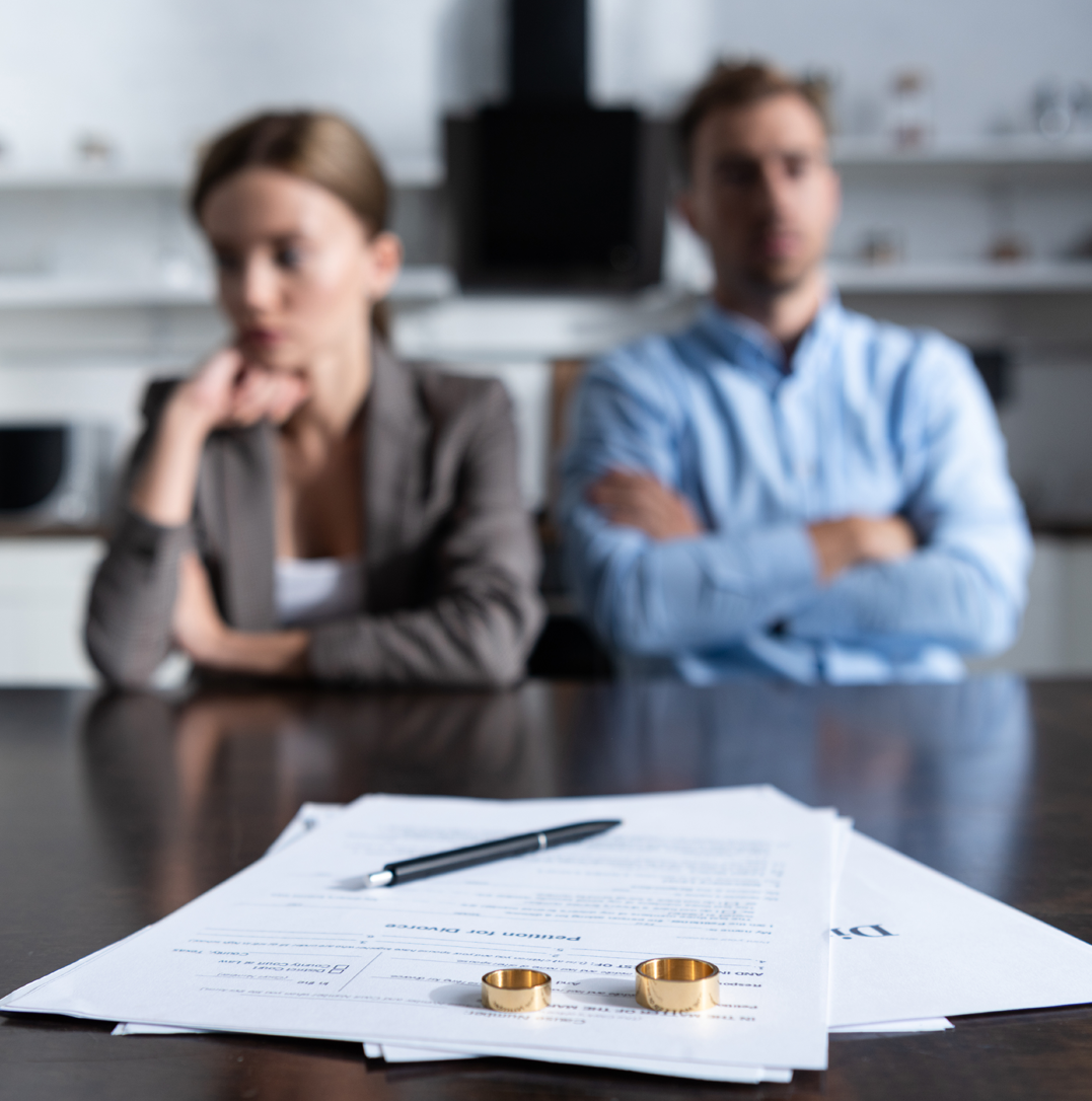 Couple sitting apart with tense body language during divorce proceedings