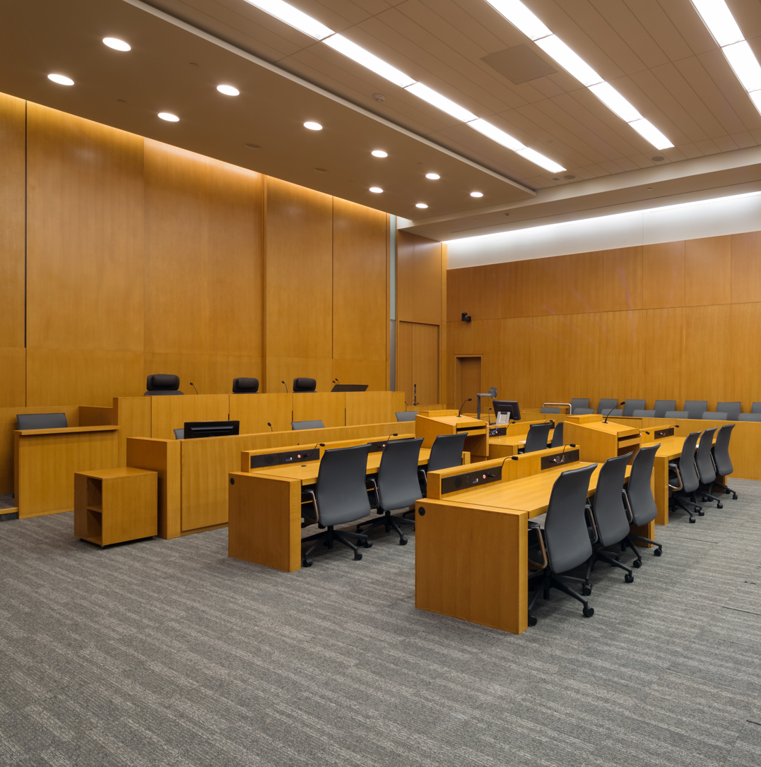 Empty courtroom with judge’s bench, witness stand, and legal seating