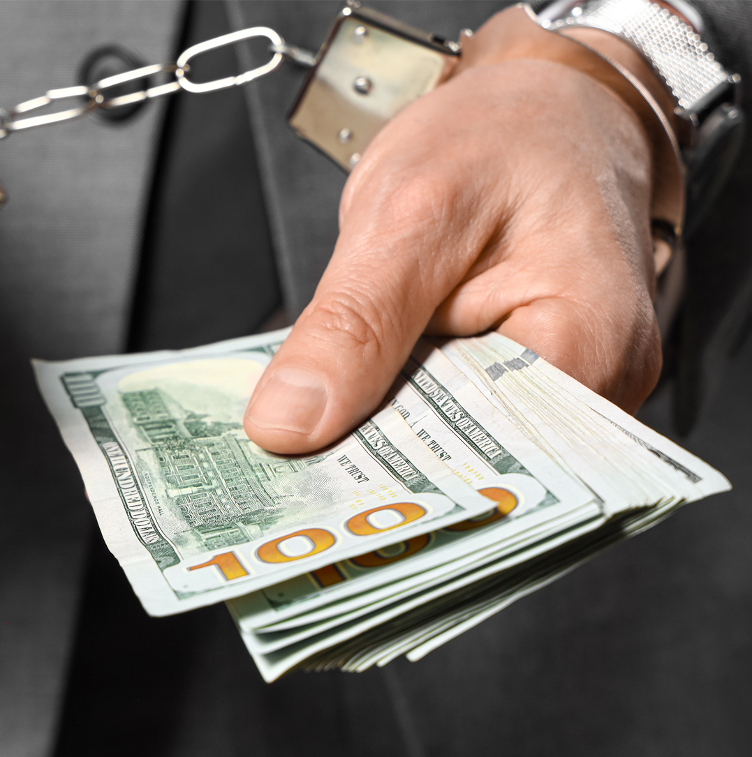 Man in a suit handing over a cash-filled envelope in a dark, secretive setting