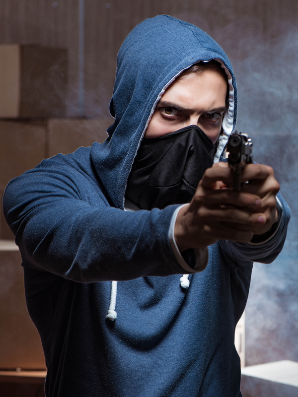 Silhouetted figure holding a firearm in a dark setting, symbolizing a firearm-related criminal investigation