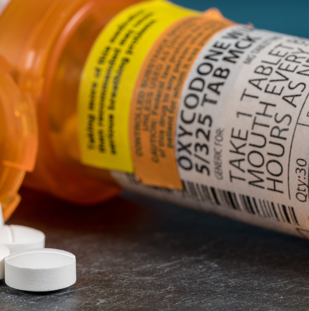 Prescription bottles and paperwork scattered on a desk, symbolizing drug fraud investigation