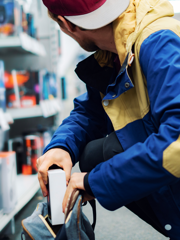 Individual in a hoodie concealing merchandise, symbolizing a shoplifting or retail theft incident